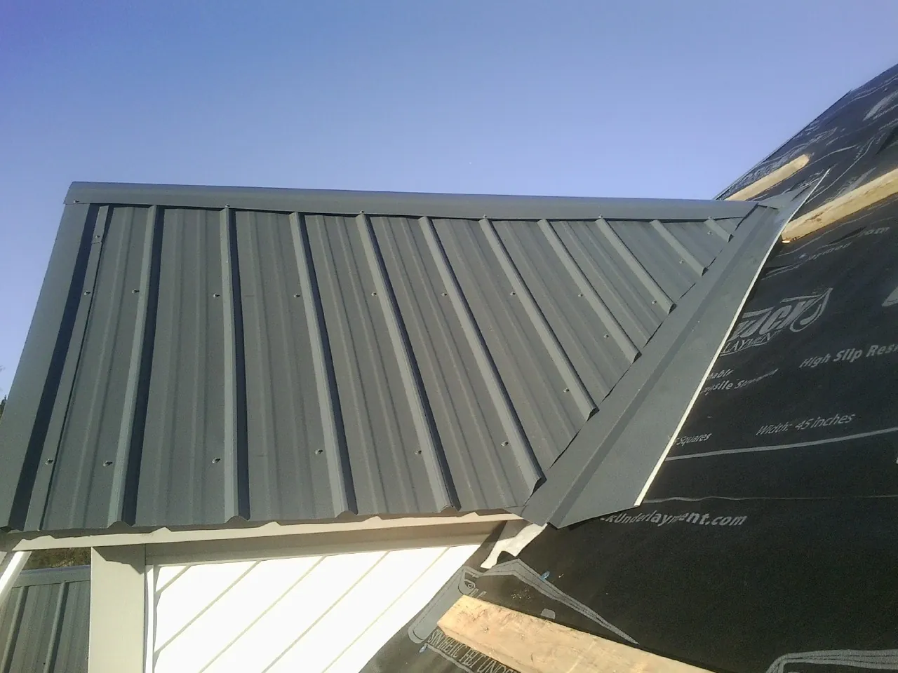 Gray metal roof panels going on over a garage gable in Julian